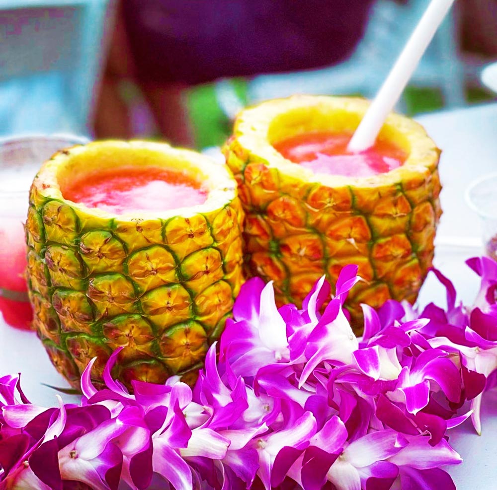enjoying a tropical cocktail out of a fresh pineapple ka moana lua