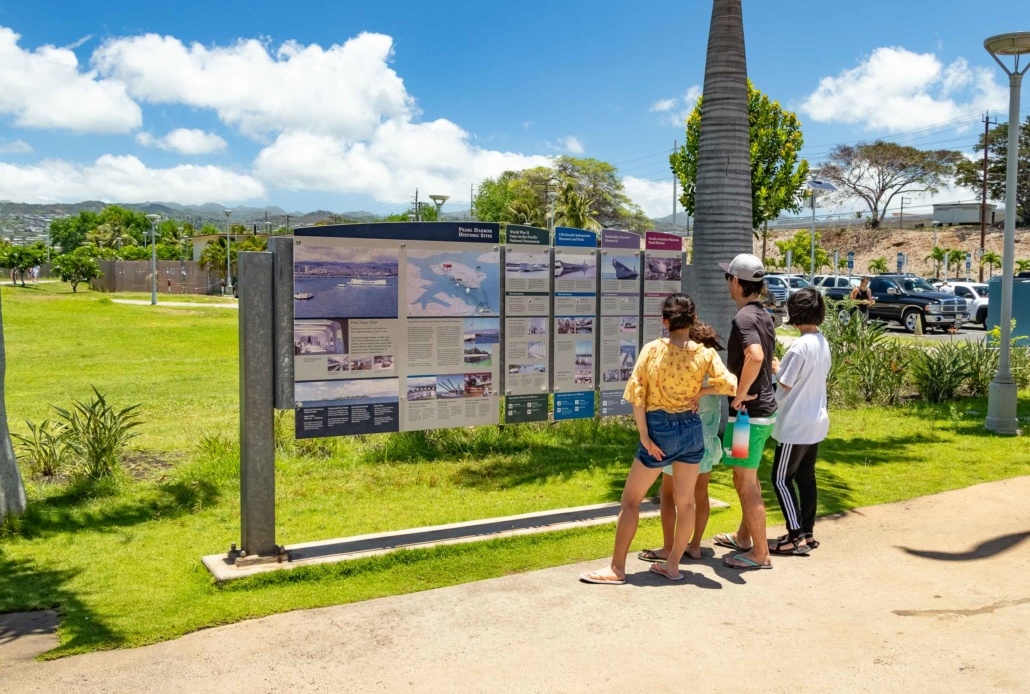 Guests at Entrance Sign Pearl Harbor Visitor Center Oahu