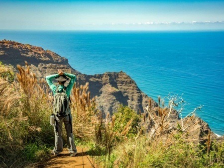 Hiking Visitor at end of the Awa Awapuhi trail Overlooking Na Pali Coast Kauai shutterstock