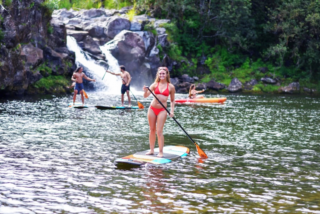 beautiful girl stand up paddle in the river umauma fall and zipline experience