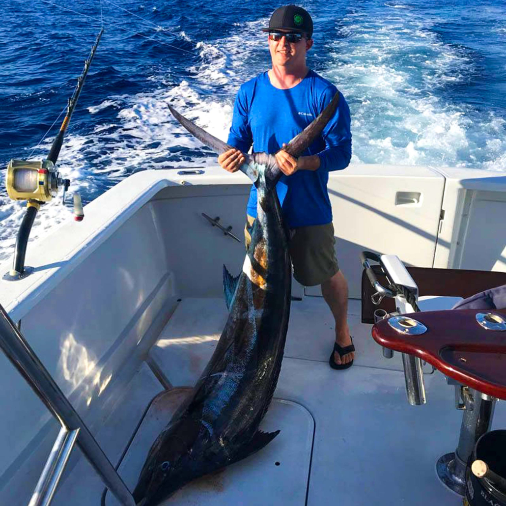 Bitemesportfishing Kona Coast Private Fishing Trips Man Holding Blue Marlin Tail