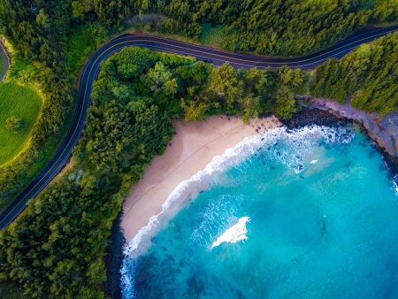aerial view of the sandy beach and curved asphalt road on the west coast of maui hawaii