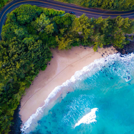 Aerial View Of The Sandy Beach And Curved Asphalt Road On The West Coast Of Maui Hawaii
