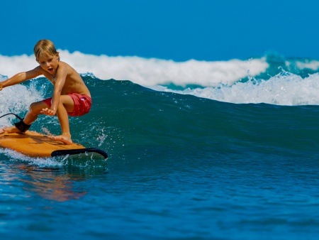young surfer learn to ride on surfboard with fun on sea waves maui hawaii