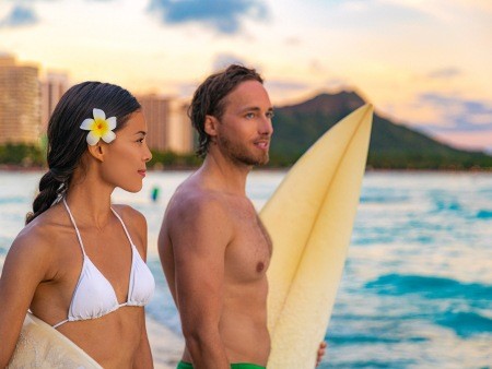 hawaii beach couple tourists surfing on waikiki beach