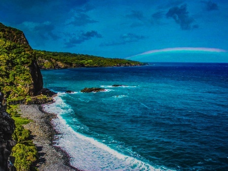 waves crashing a maui beach with a rainbow in the distance on the road to hana maui banner