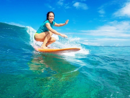 beautiful girl surfing on big transparent waves maui