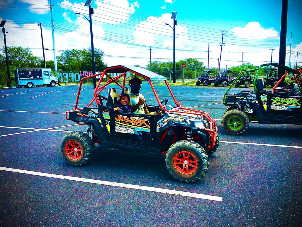 father and son driving an off road atv to explore coral crater