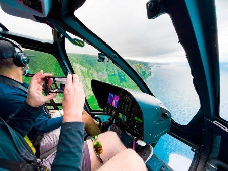 winding mountain trails jungle covered canyons and rolling green hills of big island on a helicopter tour