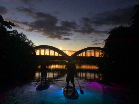 paddling on the water as the sun sets