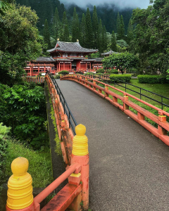 Byodo-In Temple with red bridge and lush greenery at Valley of the Temples in Oahu Hawaii