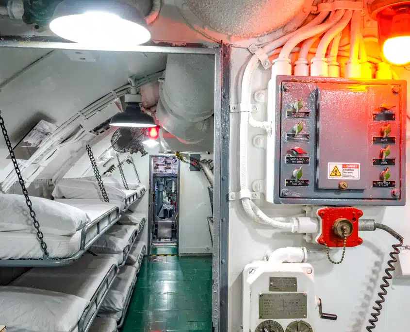 USS Bowfin submarine interior showing crew sleeping bunks and control panel at Pearl Harbor, Hawai‘i
