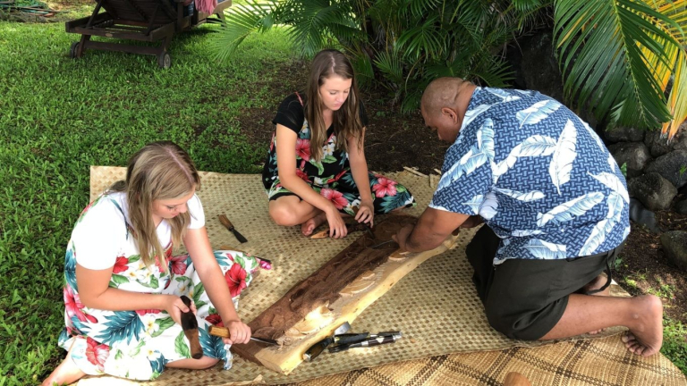 Aloha-Adventure-Farms-people-carving-wood-on-woven-mat-1