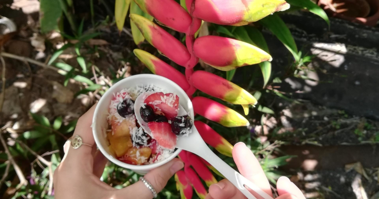 Tasting-Kauai-person-holding-fruit-bowl-near-tropical-plant-3