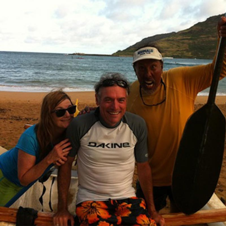 Hoku-Water-Sports-people-posing-with-paddle-on-beach